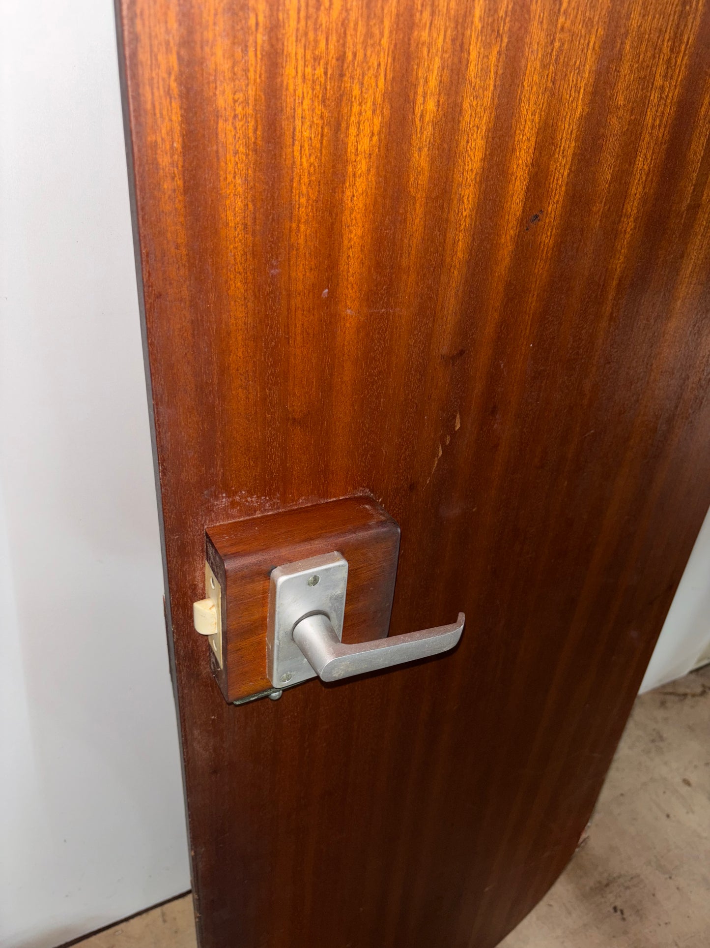 Wooden door with a metal handle and lock mechanism.