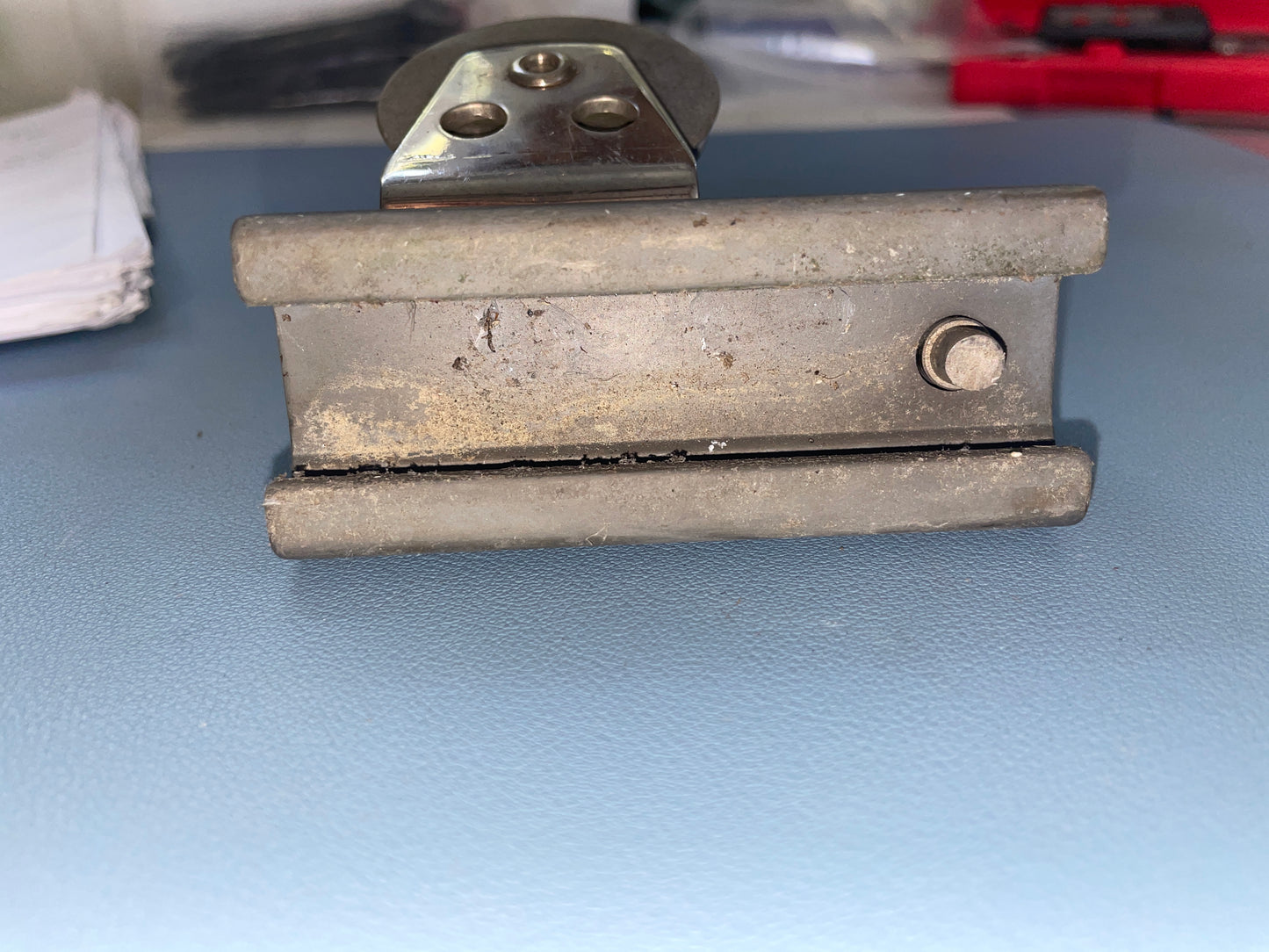 Metal clamp on a blue surface with blurred background