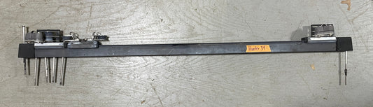 Long metal tool with various attachments on a gray surface