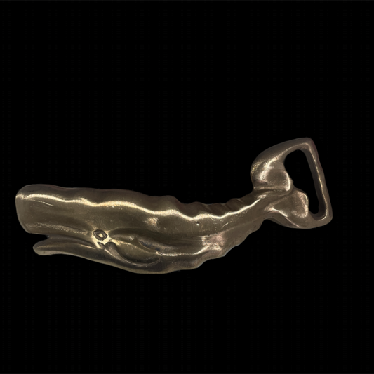 Metallic whale-shaped belt buckle on a black background