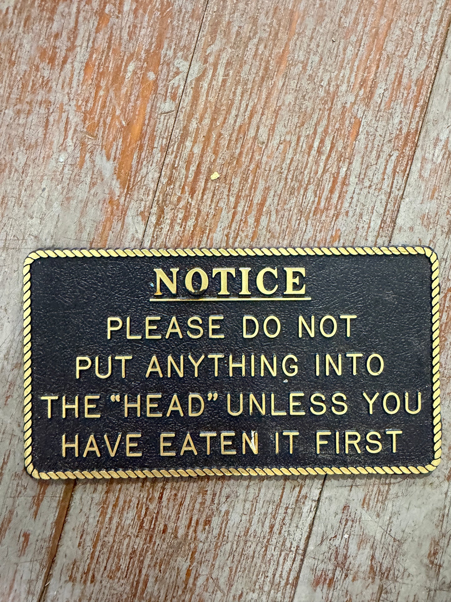 Plastic “NOTICE - Please Do Not Put Anything Into The “Head” Unless You Have Eaten It First” Plaque