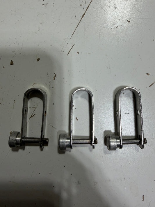 Three metal U-bolts on a white surface with visible shadows.