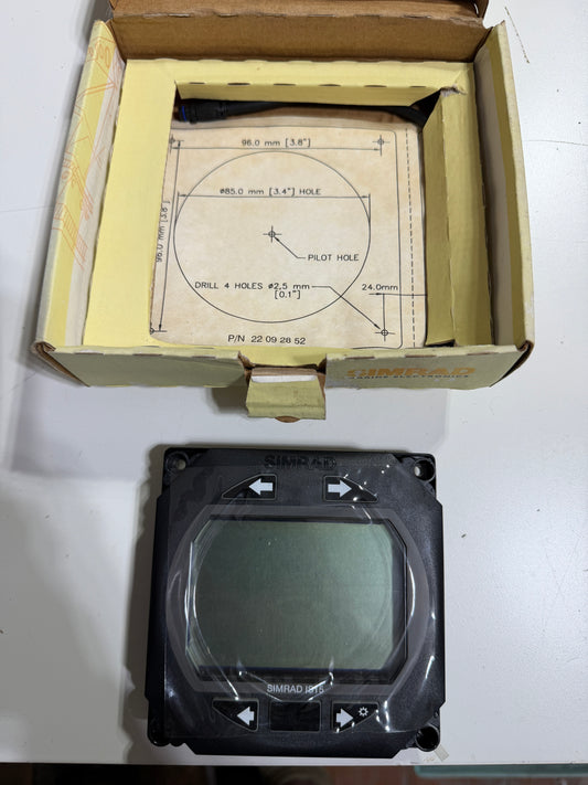 Electronic component on a white surface next to an open cardboard box with technical drawings.