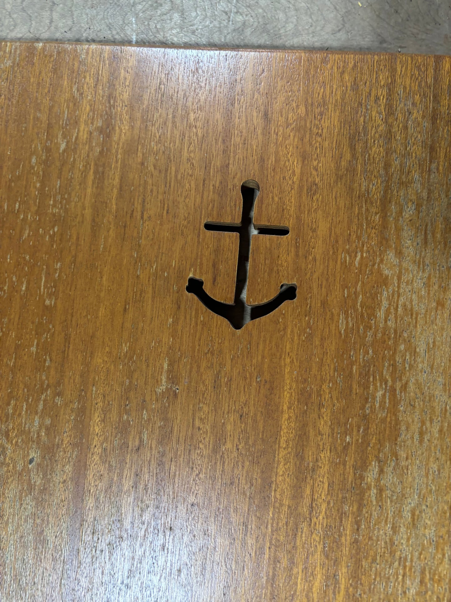 Black anchor-shaped hook on a wooden surface