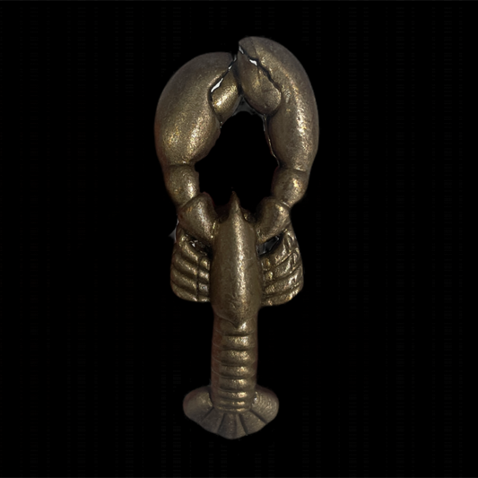 Metallic lobster charm on a black background