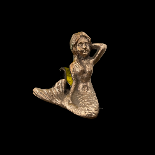 Silver mermaid figurine on a black background