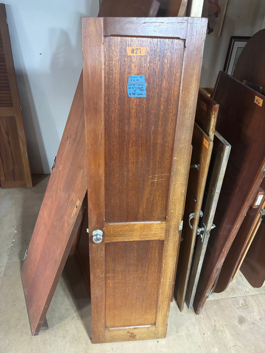 Wooden cabinet doors with a visible number tag on a floor.