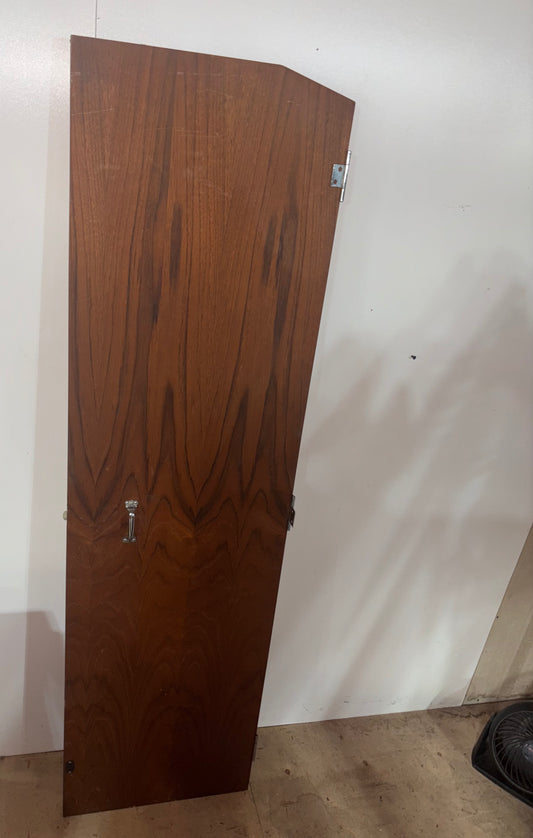 Wooden door leaning against a white wall