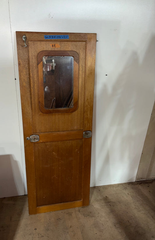 Wooden door with glass panel and metal handles on a white wall.