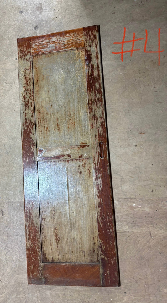 Old wooden door with visible wear on a concrete floor, labeled '#4'.