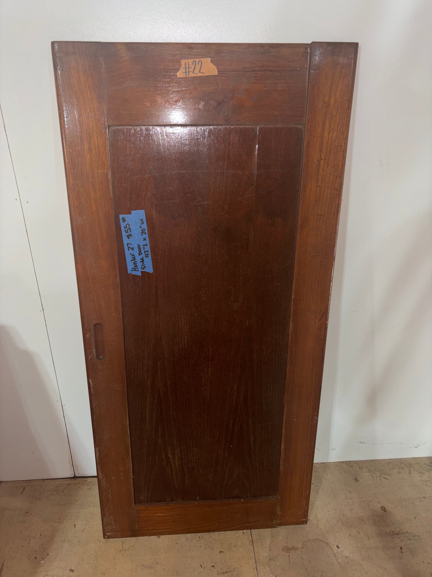 Wooden panel with a blue label on a white background