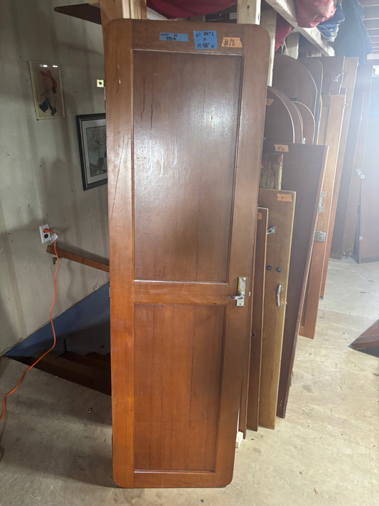 Wooden doors stacked against a wall in an indoor setting