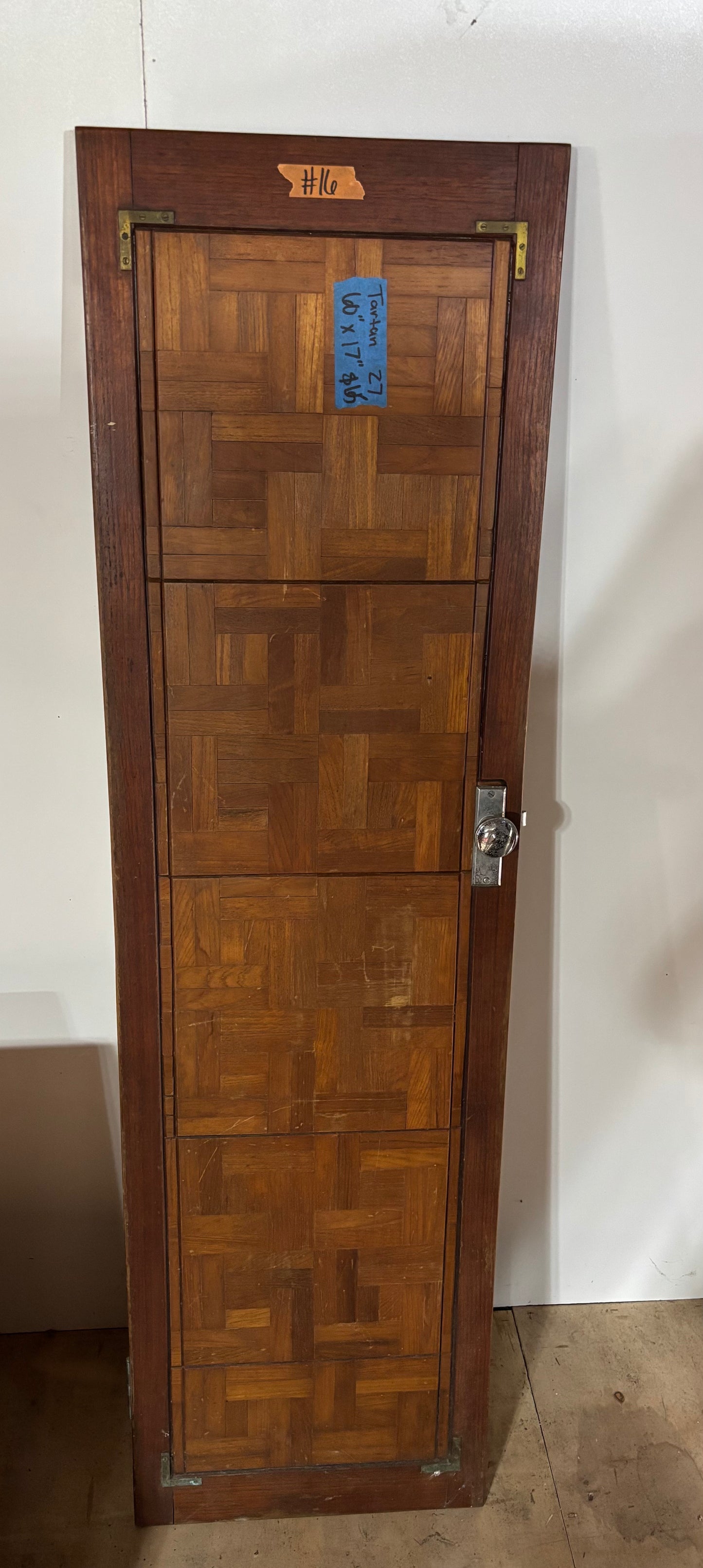 Wooden door with a geometric pattern on a white wall