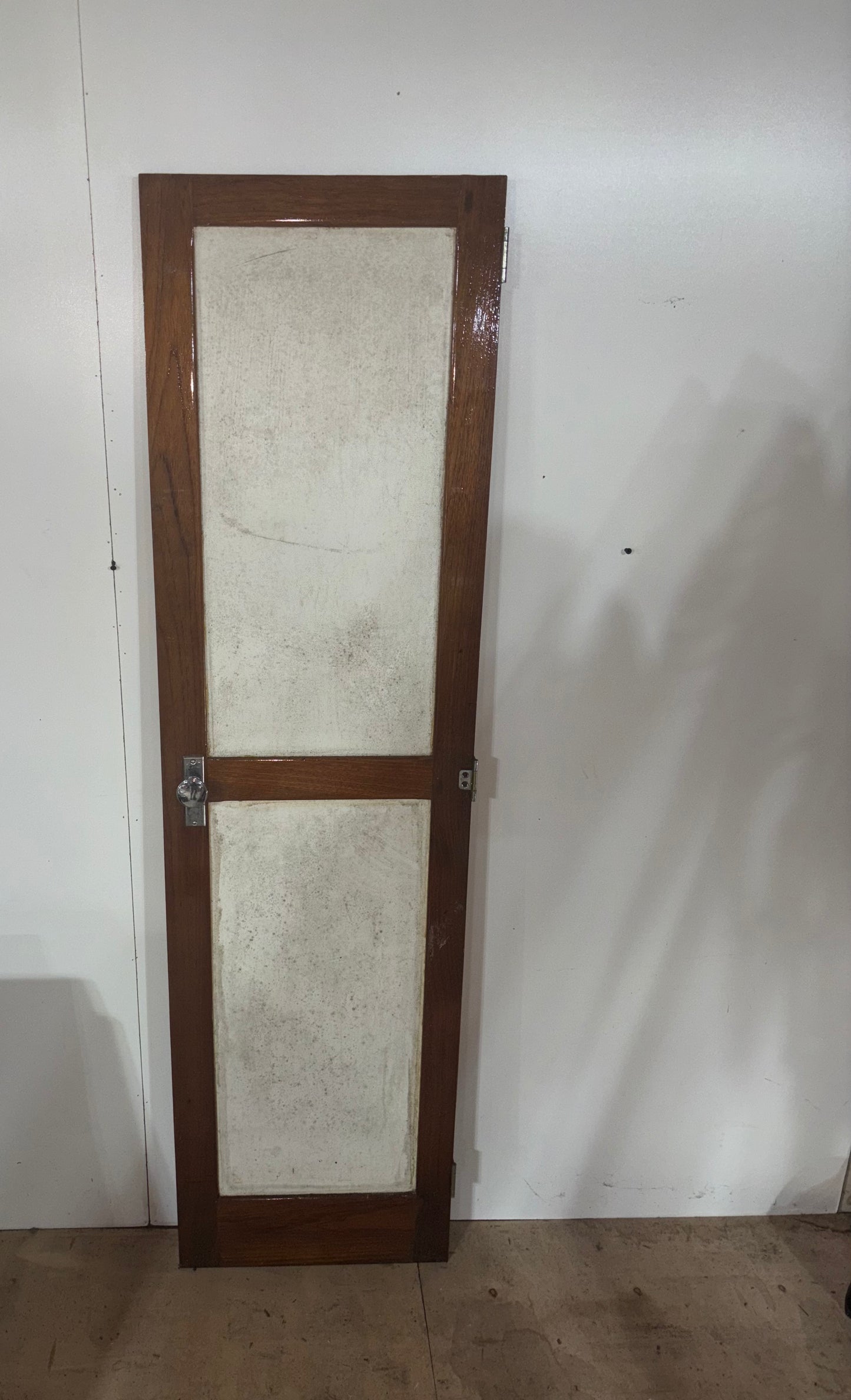 Wooden door with glass panels against a white wall