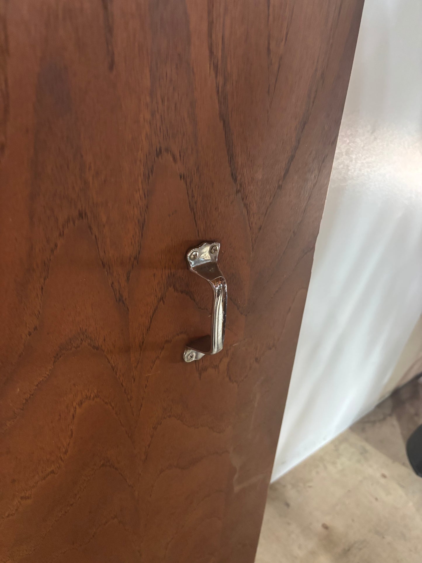 Wooden cabinet with a metal handle on a white background
