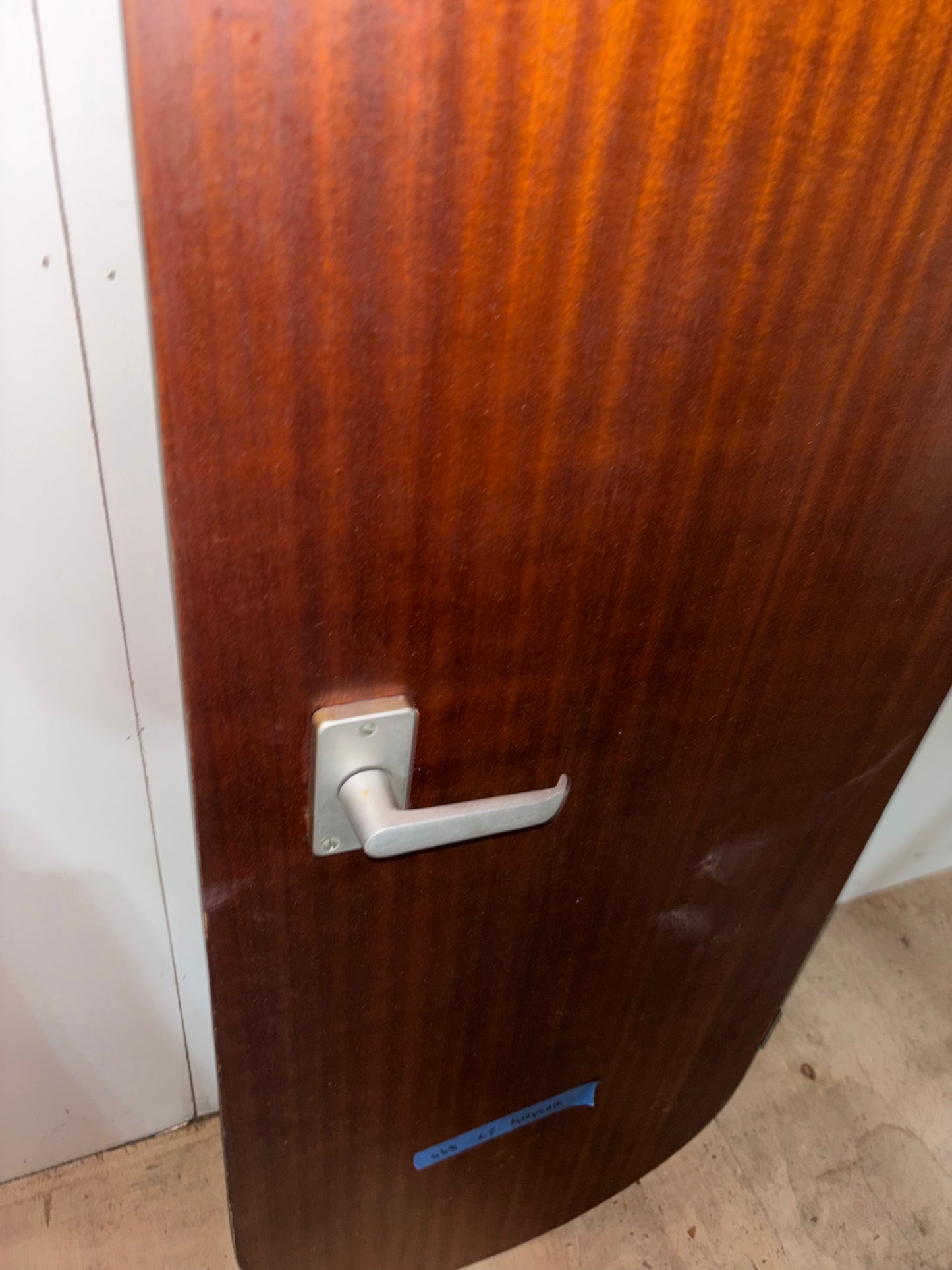 Wooden door with a metal handle on a plain background