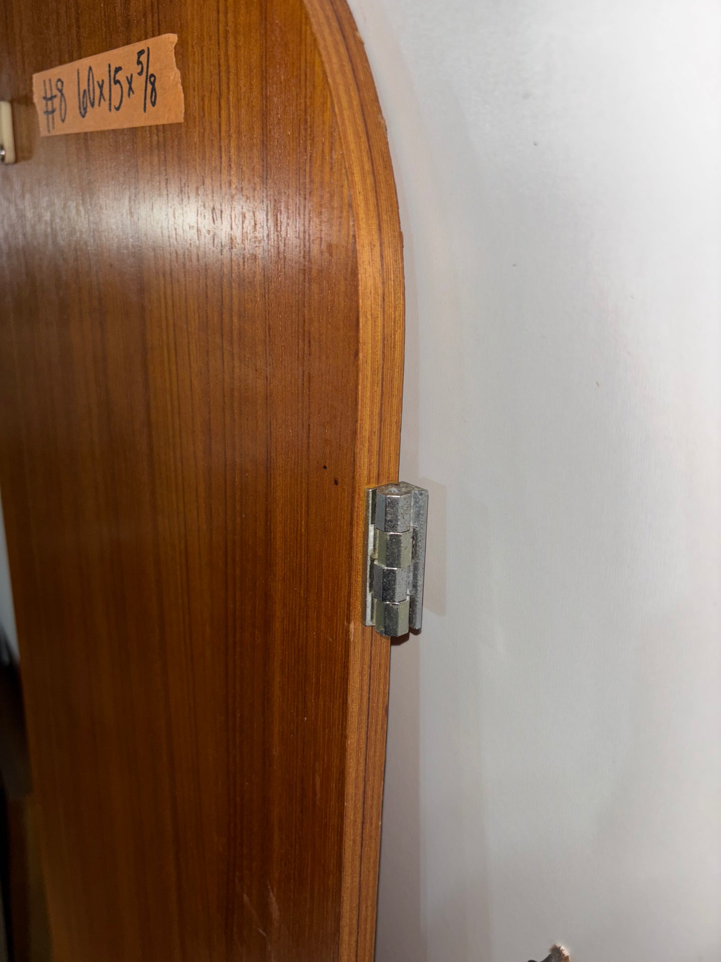Wooden panel with a metal hinge on a white background