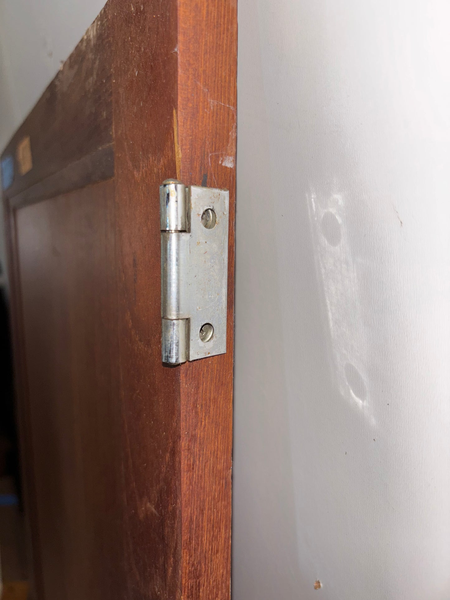 Metal hinge on a wooden door with a white background