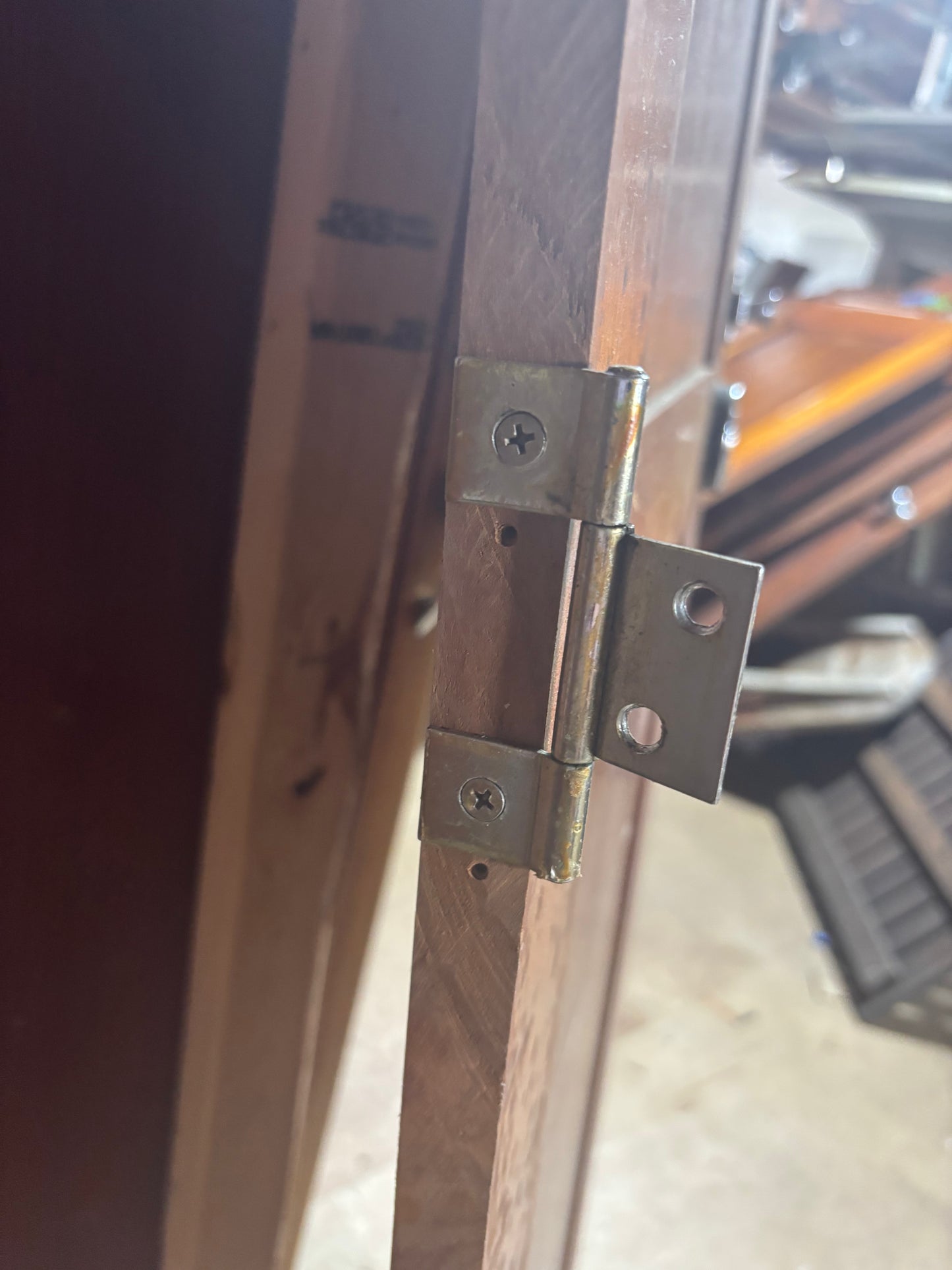 Close-up of a wooden door with metal hinges, blurred background