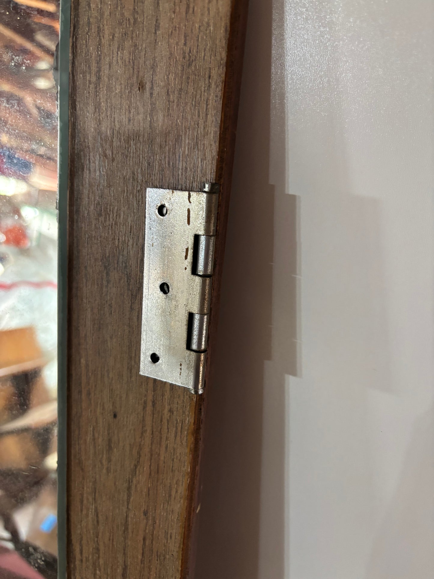 Close-up of a wooden door with a metal hinge.
