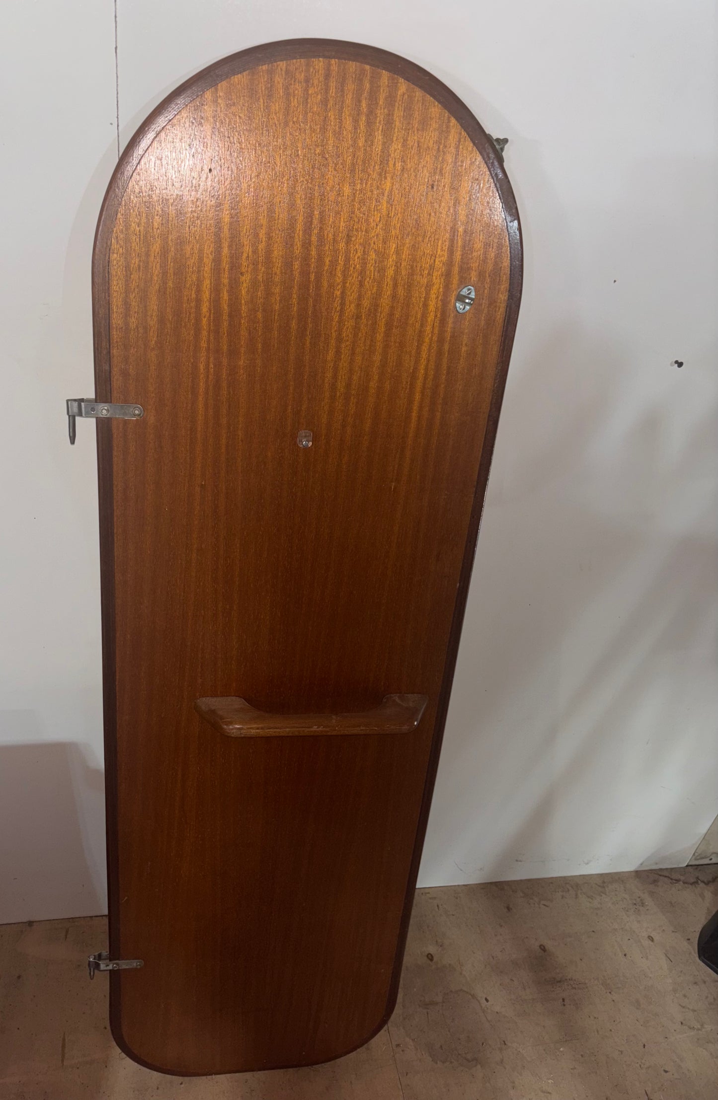 Wooden guitar case against a white wall