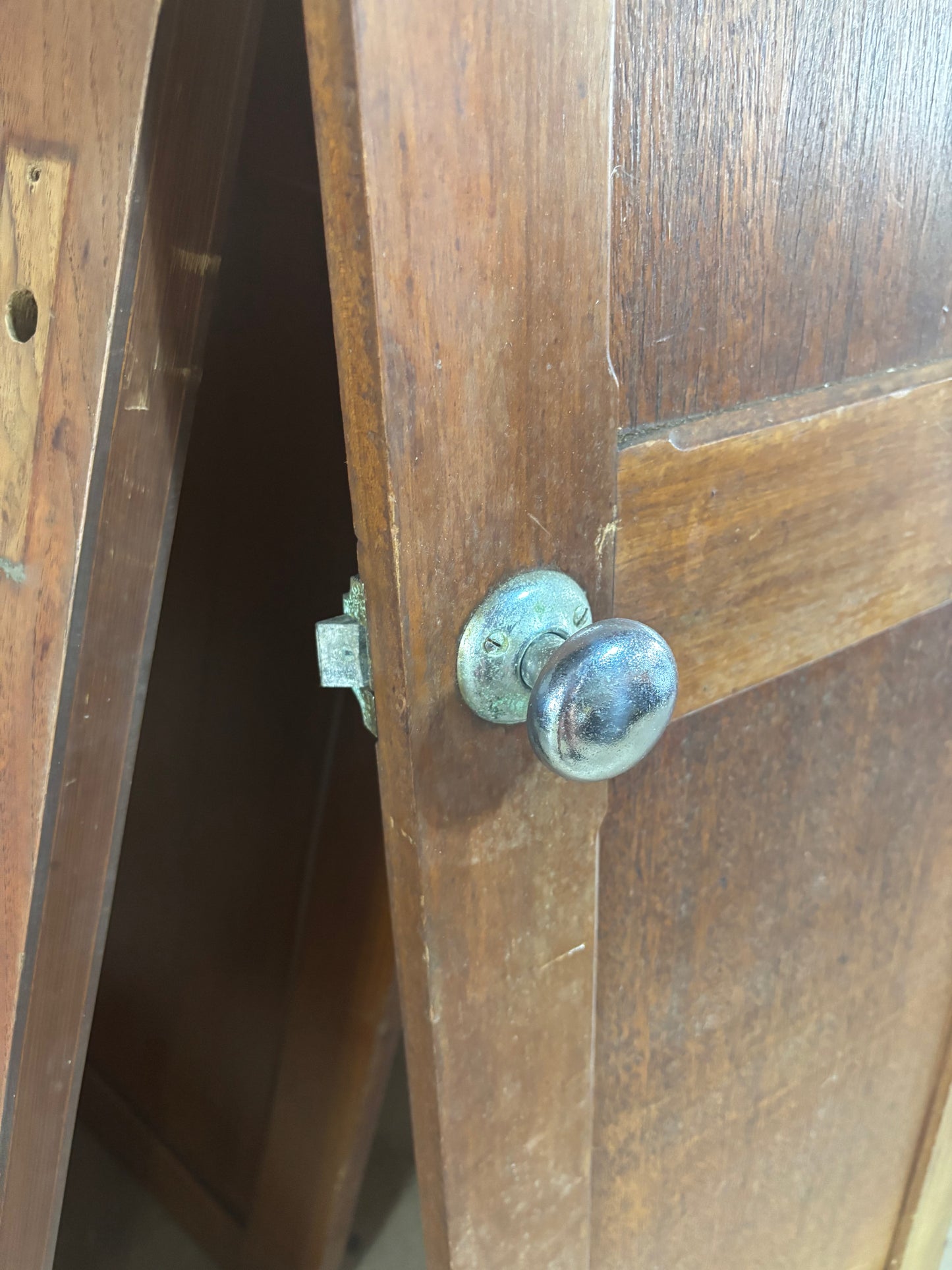 Close-up of a wooden door with a metal doorknob