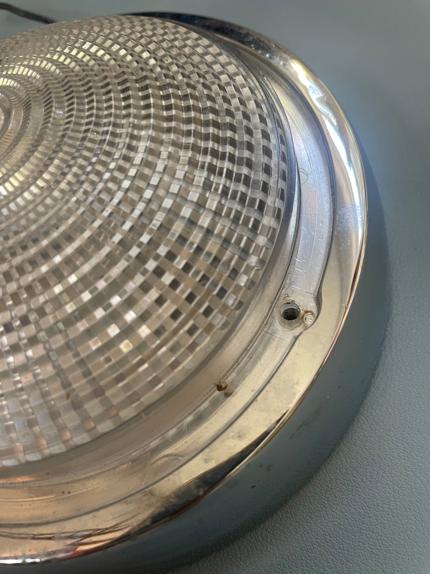 Close-up of a metallic light fixture with a textured surface.