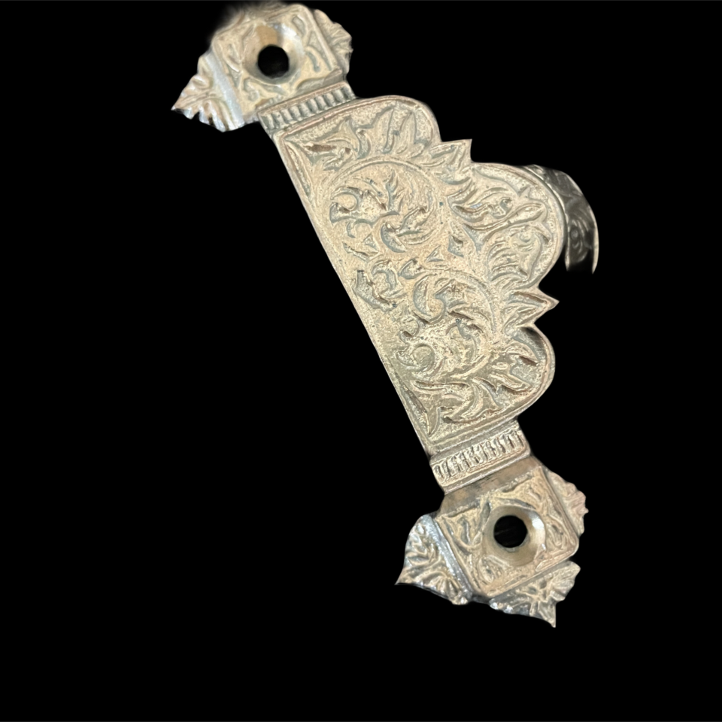 Decorative metal object with intricate patterns on a black background